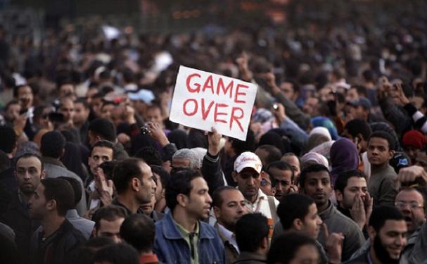 An anti-government protester holds a sign reading "Game Over" in Tahrir square in downtown Cairo, Egypt, Saturday, Jan. 29, 2011. Thousands of anti-government protesters returned to Cairo's central Tahrir Square, chanting slogans against Egyptian President Hosni Mubarak and demanding his departure. (AP Photo/Ben Curtis)